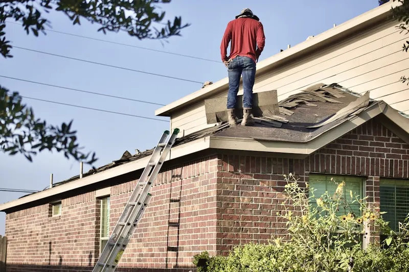 Professional roofer working on a residential roof in Holcomb Mills
